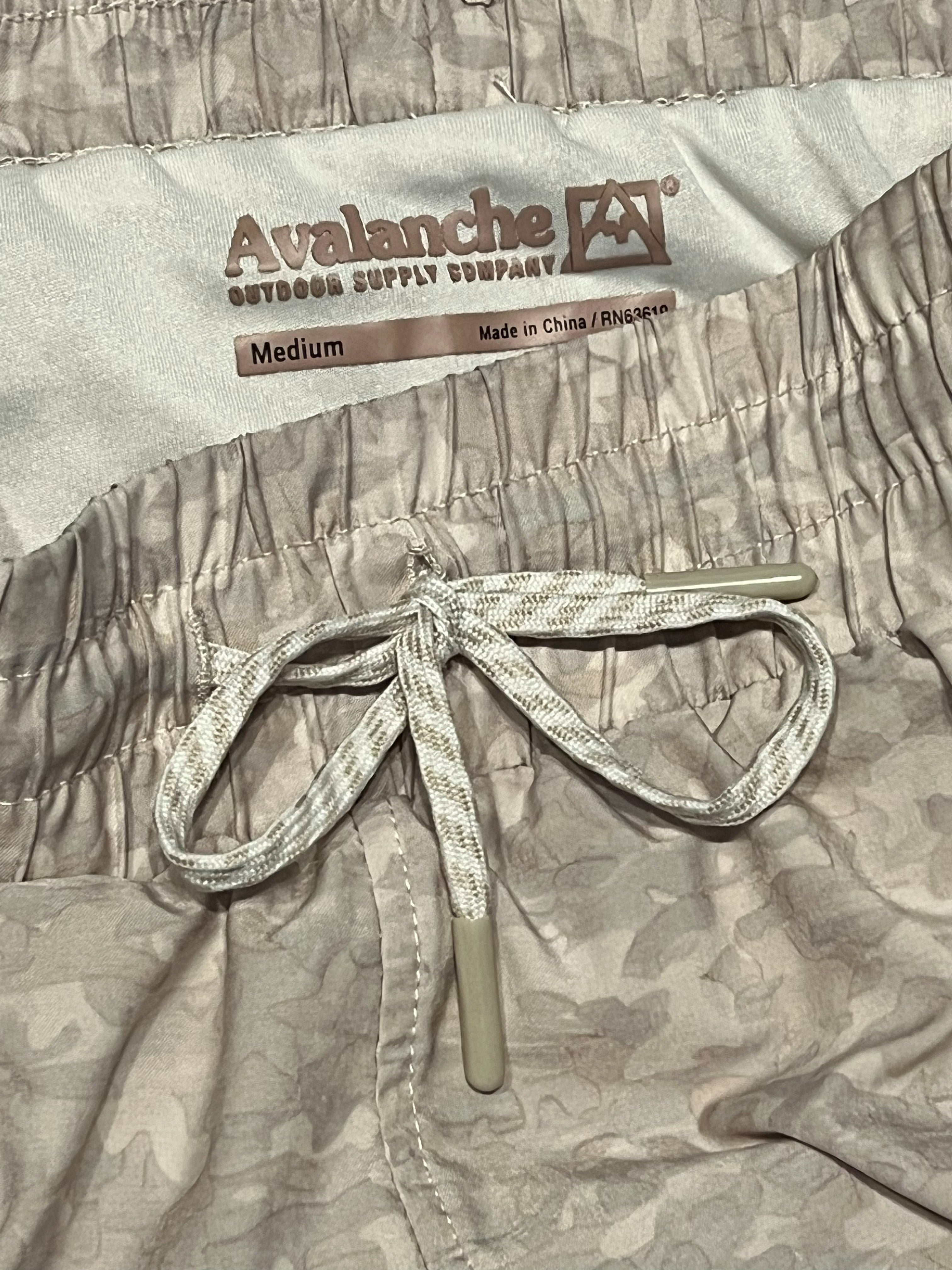 Close-up of a pair of camouflage-patterned shorts with a white drawstring and a visible inner label reading Avalanche.
