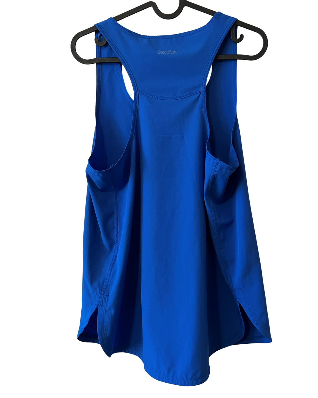 A bright royal blue sleeveless tank top with side pockets, hanging on a black hanger against a plain white background.