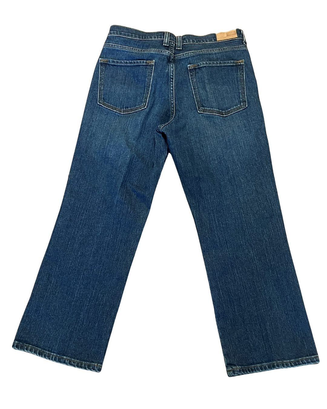 Back view of a pair of blue denim jeans on a solid white background.