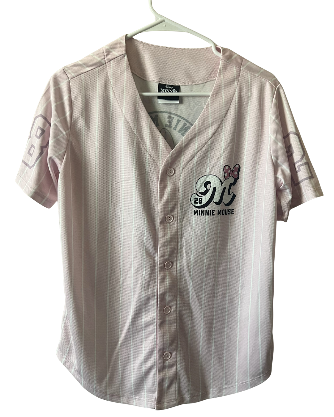 A short-sleeve button-front baseball-style top hanging on a hanger, featuring a pale blush pink and white pinstripe pattern. The left chest has a Minnie Mouse graphic with the text 'MINNIE MOUSE' and '93' beneath it.