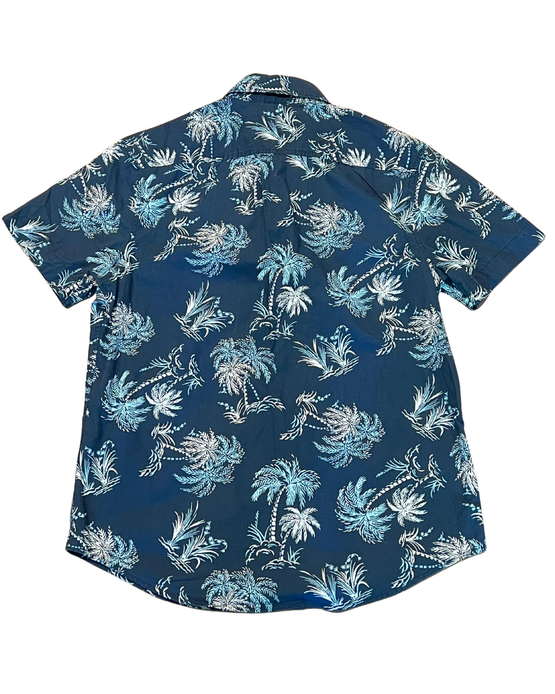 A short-sleeve button-up shirt with a blue base and a light blue and white palm tree pattern, shown flat against a white background.
